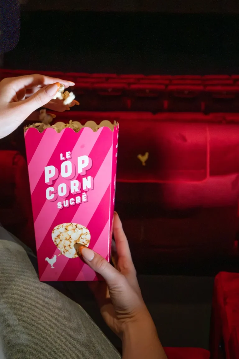 Pop-corn sucré tenu devant les fauteuils rouges du Pathé Odysseum