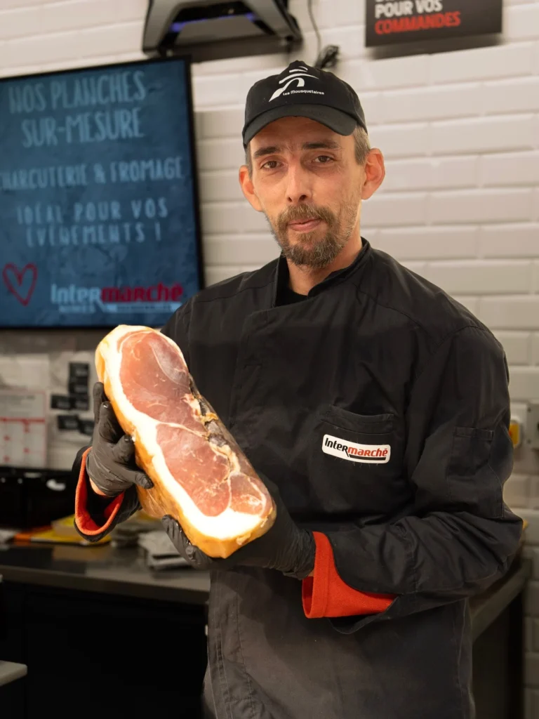 Boucher d’Intermarché Nîmes Vacquerolles présentant un jambon