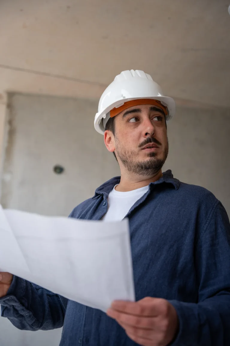 Conseiller Novanéa casqué, plan en main, sur un chantier